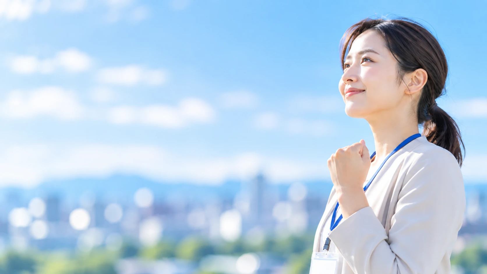 青空の下で前を見つめる医療事務スタッフの女性