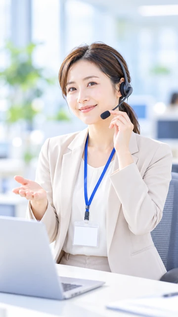 ヘッドセットをつけて笑顔で応対する医療事務スタッフの女性